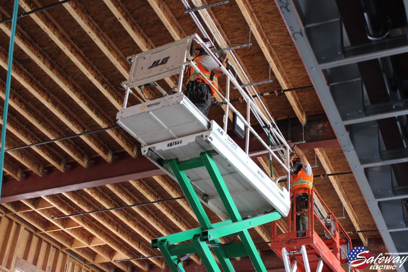 Safeway electricians on a scissor lift during the Fitness Mania build-out in Riverside