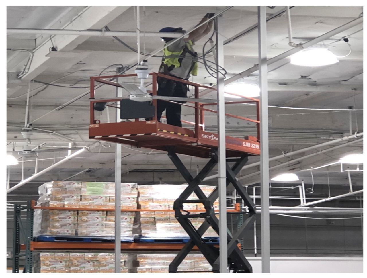 Safeway electrician on a lift servicing lighting at a UPS facility in Southern California
